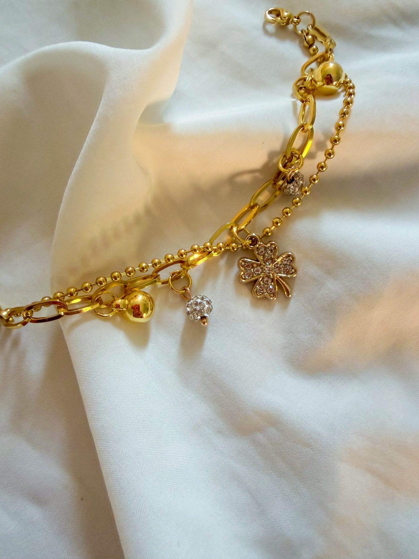 Bracciale “Tessa” in acciaio inox, con doppia catena e ciondoli. Color oro.