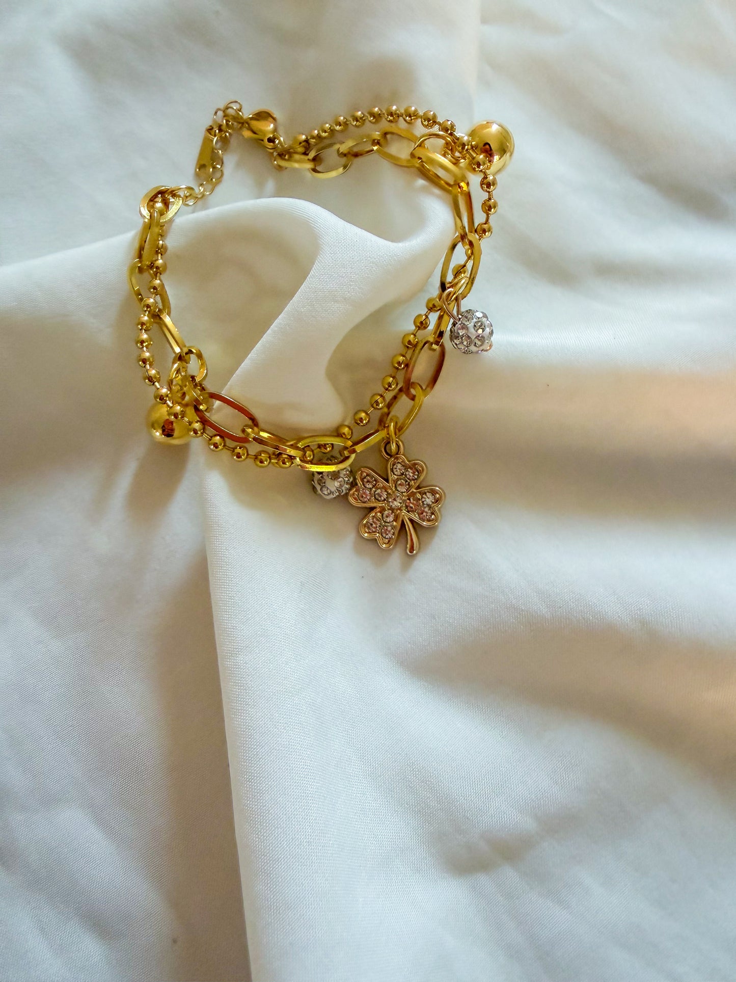 Bracciale “Tessa” in acciaio inox, con doppia catena e ciondoli. Color oro.