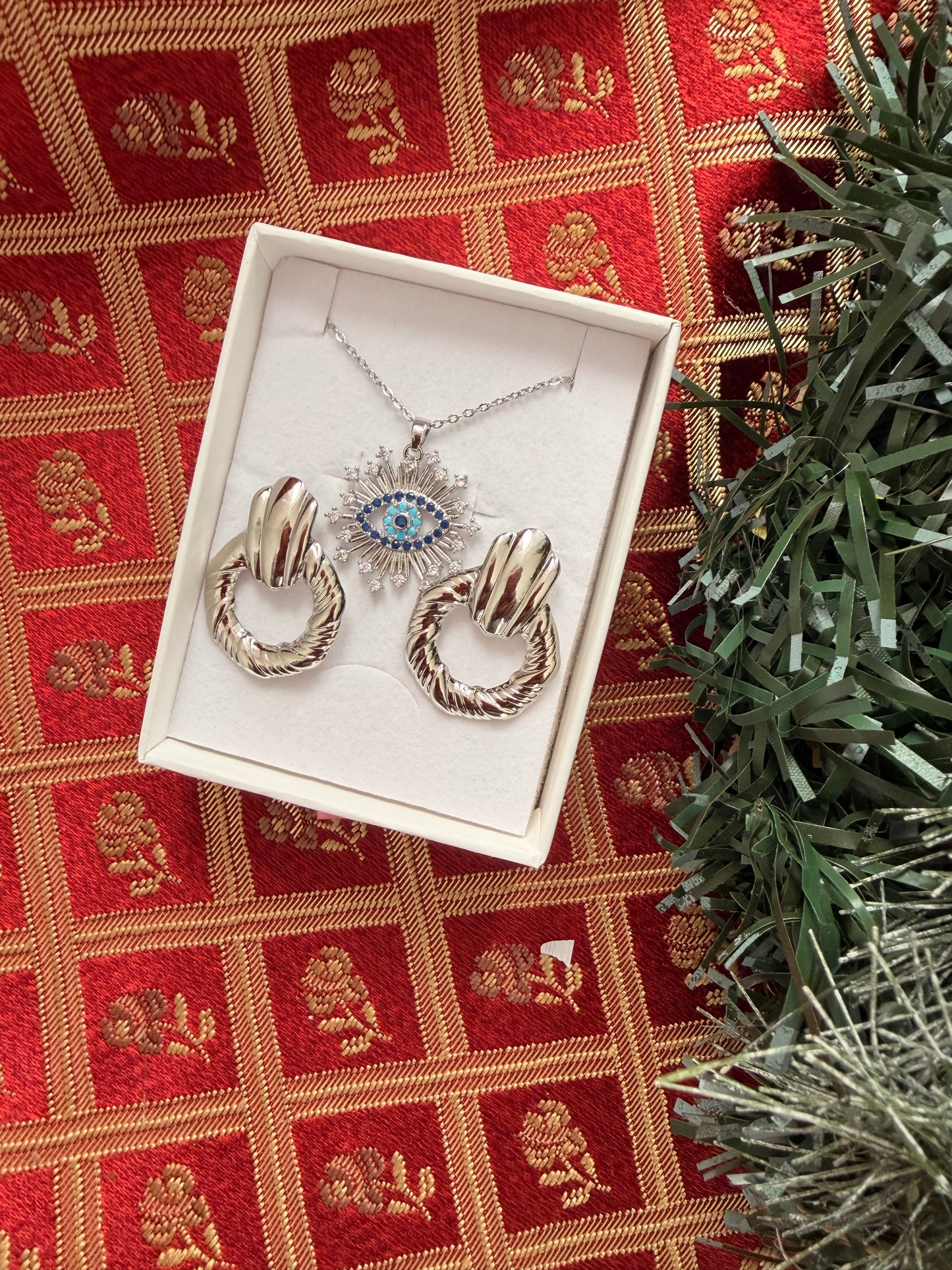 Set natalizio: collana con occhio e strass+orecchini a lobo. Colore argento. In acciaio inox