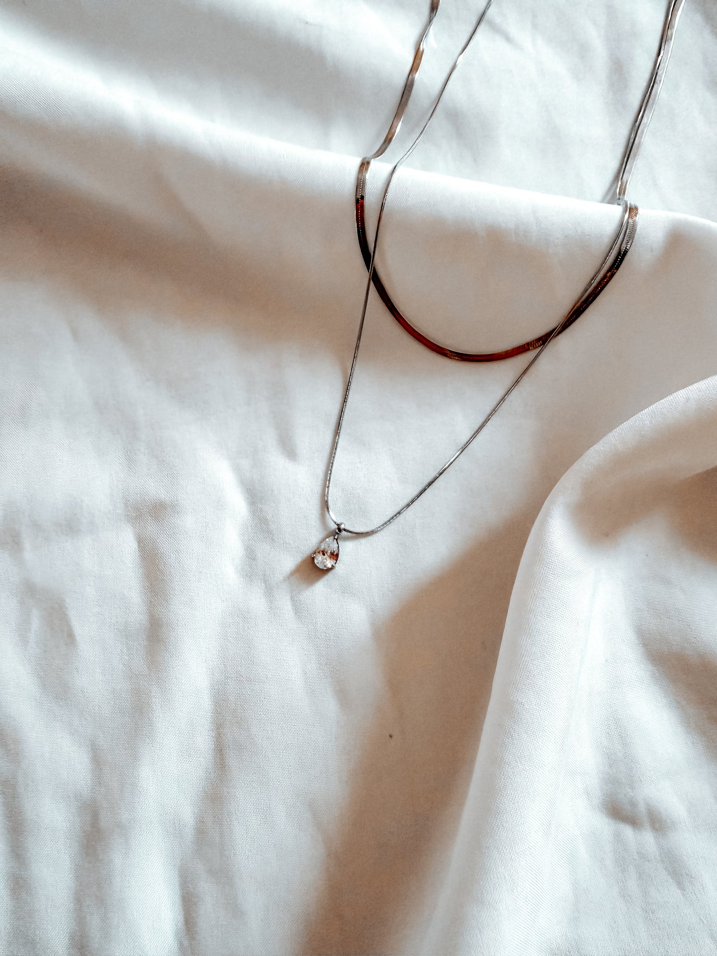 Collana “Elizabeth” in acciaio inox con brillantino pendente. In oro e argento