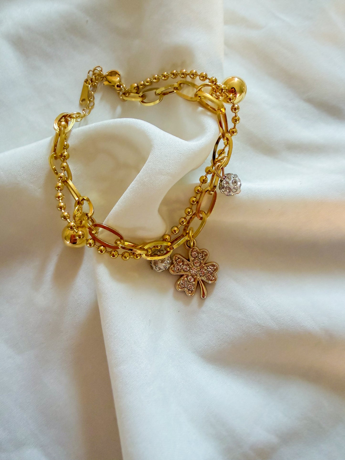 Bracciale “Tessa” in acciaio inox, con doppia catena e ciondoli. Color oro.